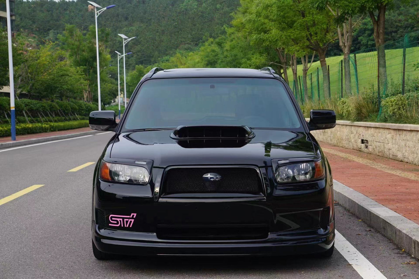 Black SUV with STI logo on a road
