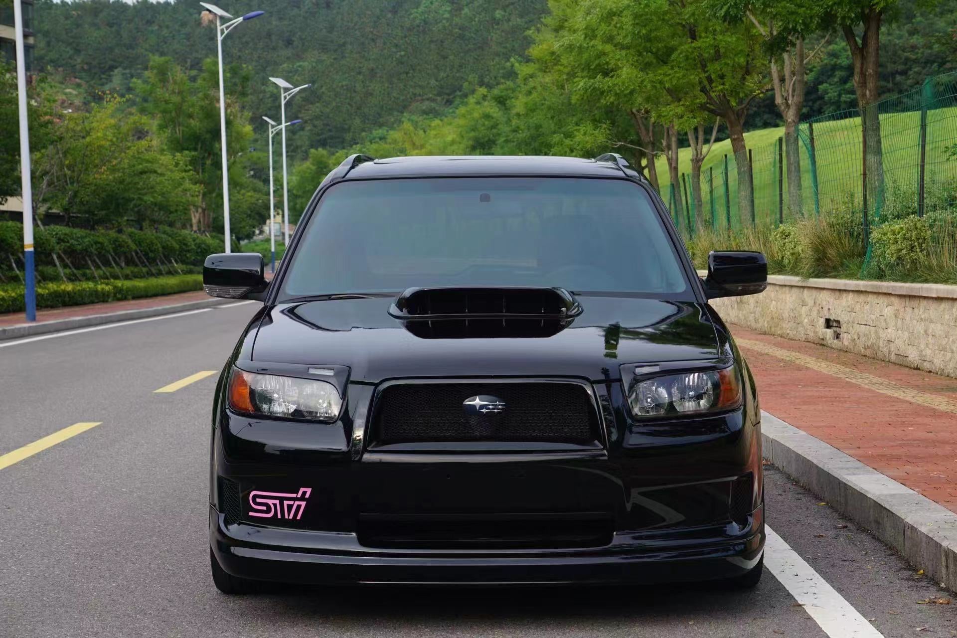 Black SUV with STI logo on a road